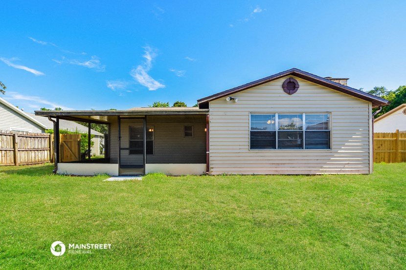 a small white house with a porch and a lawn