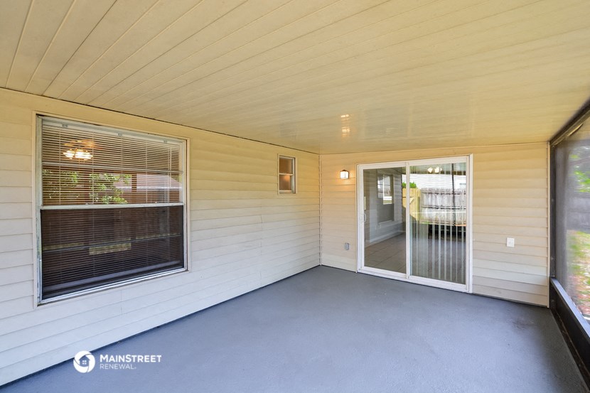 a covered porch with a sliding glass door and a window