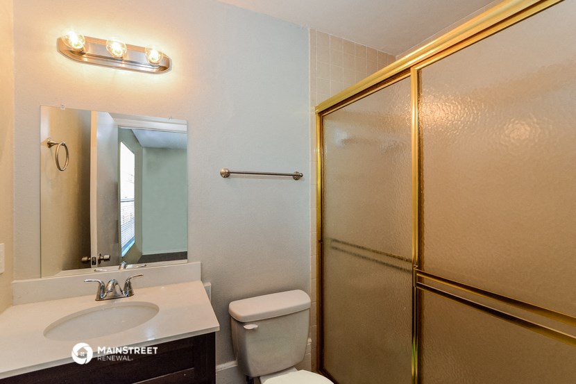 a bathroom with a shower sink and toilet and a mirror