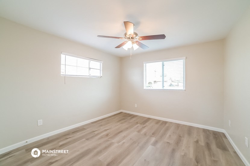 a living room with hardwood floors and a ceiling fan