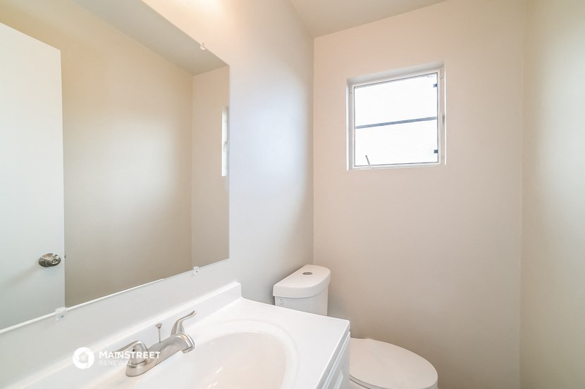 a bathroom with a toilet and a sink and a mirror