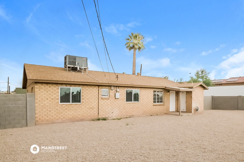 a small brick house with a palm tree in the background