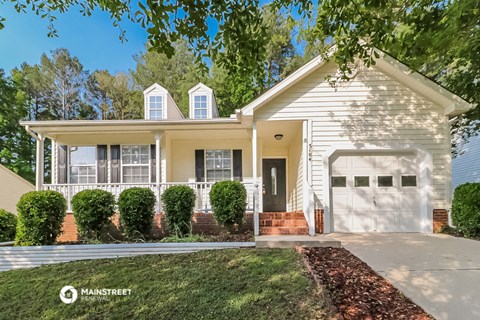 a white house with a white garage door and a lawn