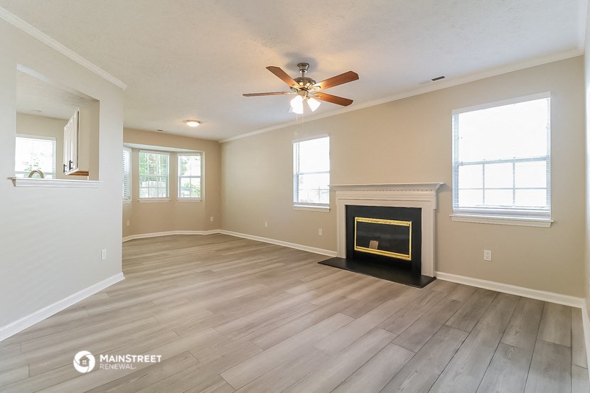 the living room with fireplace and ceiling fan