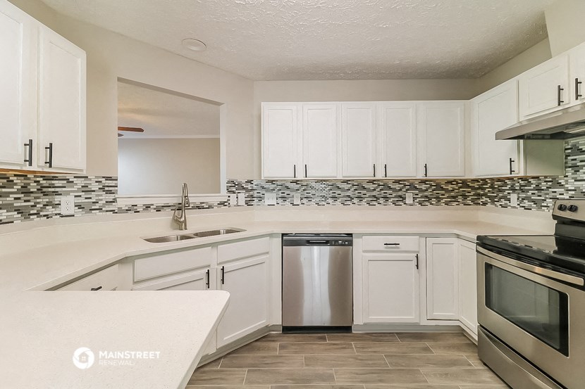 a kitchen with white cabinets and stainless steel appliances