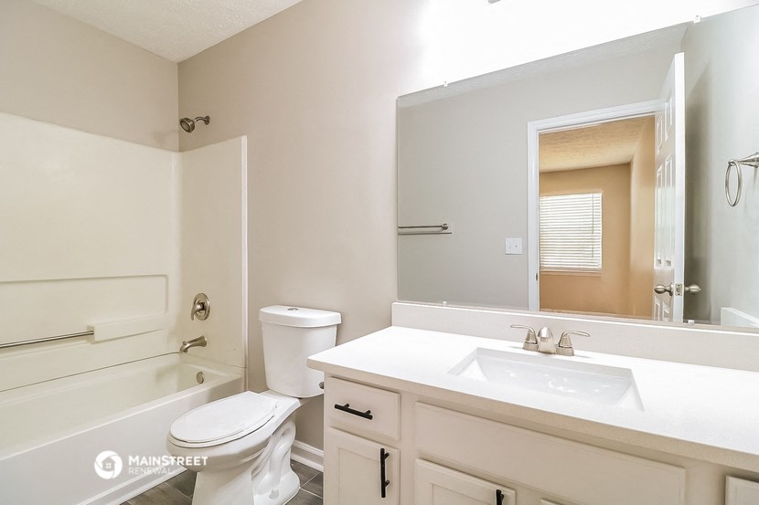a bathroom with a sink toilet and a mirror