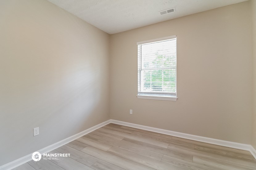 an empty room with wooden floors and a window
