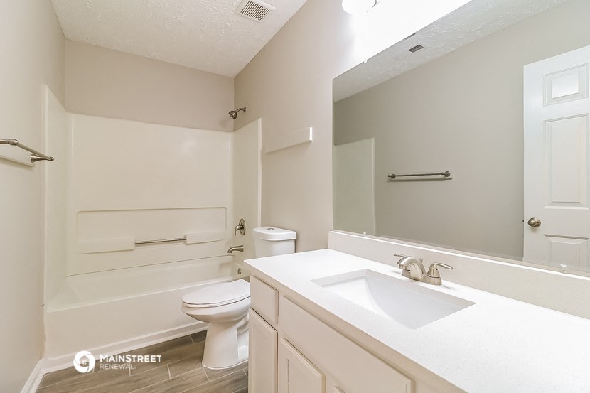 a bathroom with a sink and a toilet and a mirror