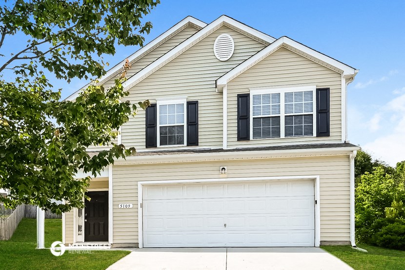 a tan house with a white garage door