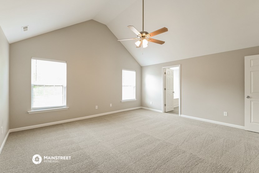 the spacious living room with ceiling fan in a new home