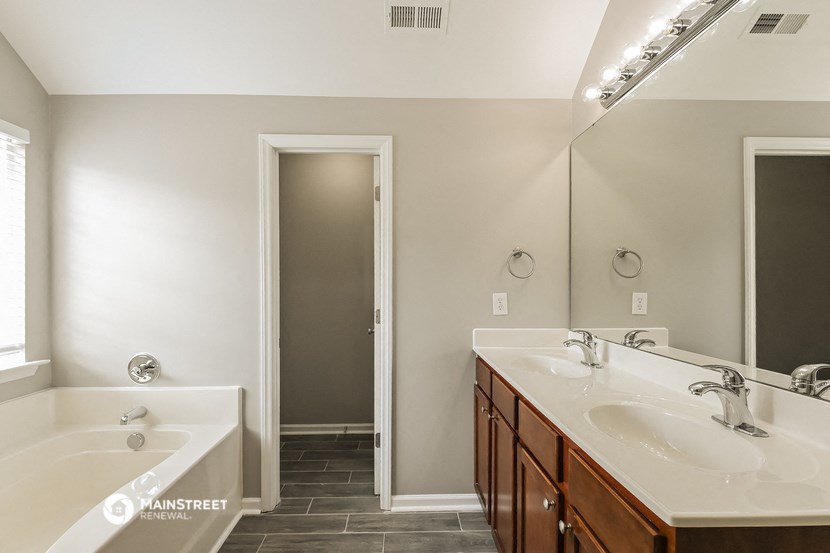a bathroom with two sinks and a tub and a mirror
