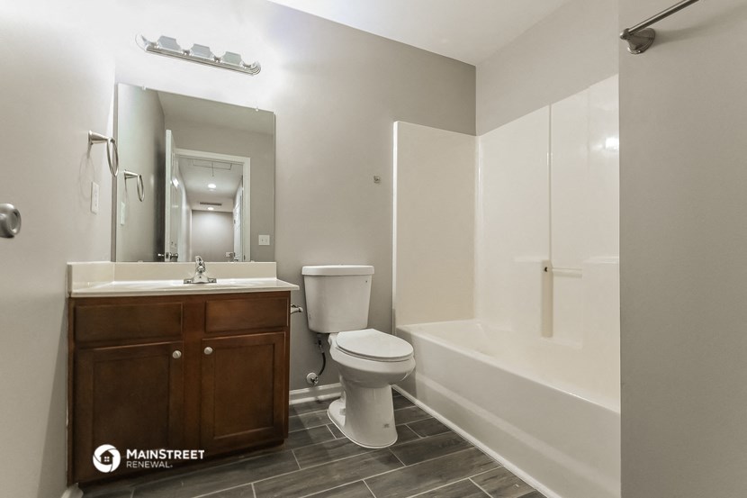 a bathroom with a toilet sink and tub and a mirror