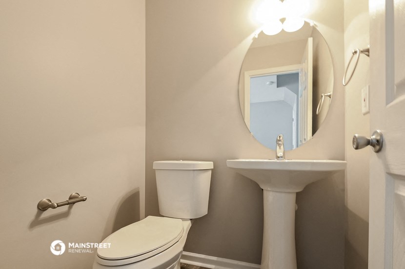 a bathroom with a toilet and a sink and a mirror