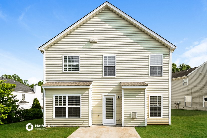 a white house with white siding and a driveway