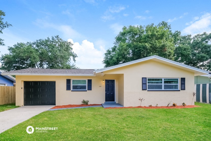 a white house with a lawn and a black garage door