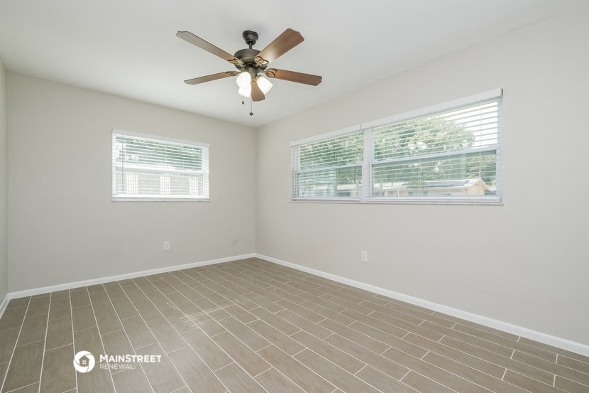 the living room has a ceiling fan and a large window