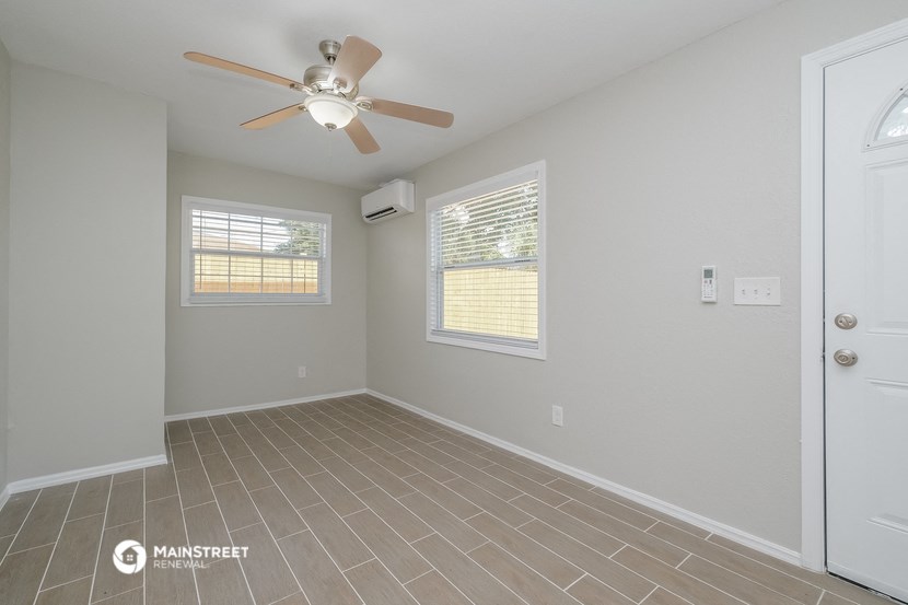 the living room of an empty house with a ceiling fan