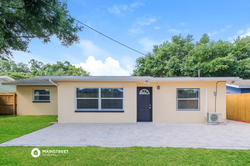the front of a house with a driveway and a blue door