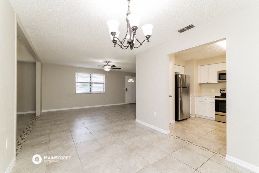 an empty kitchen and living room with a ceiling fan