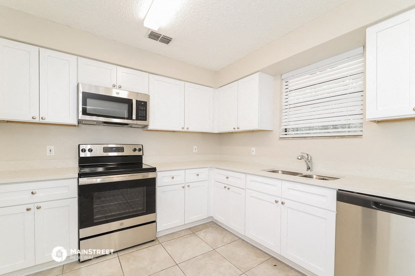 a kitchen with white cabinets and stainless steel appliances