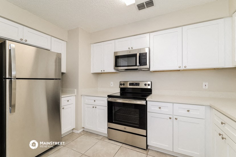 a kitchen with stainless steel appliances and white cabinets