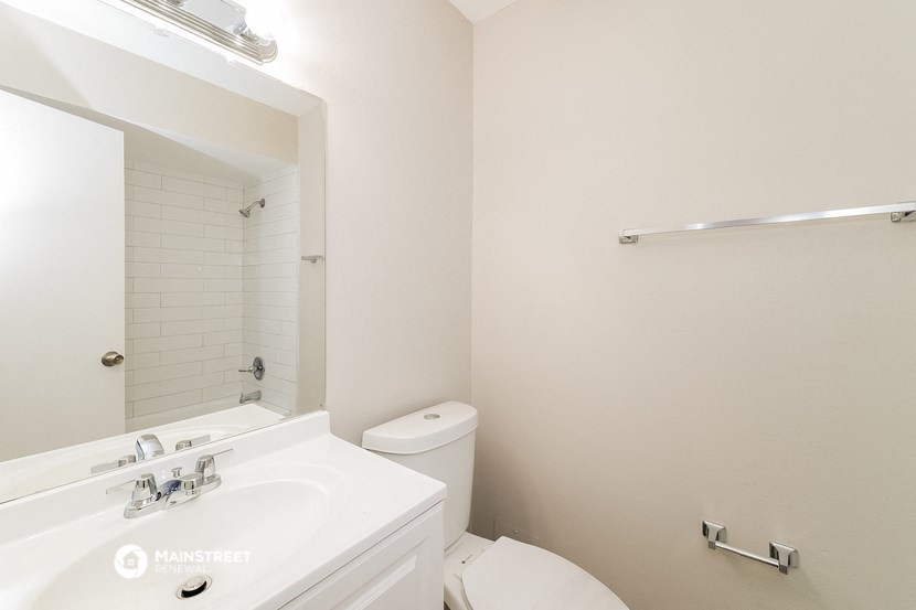 a bathroom with a sink toilet and a mirror