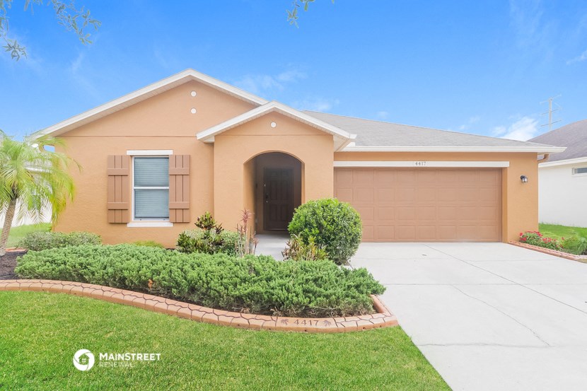 a beige house with a driveway and a garage door