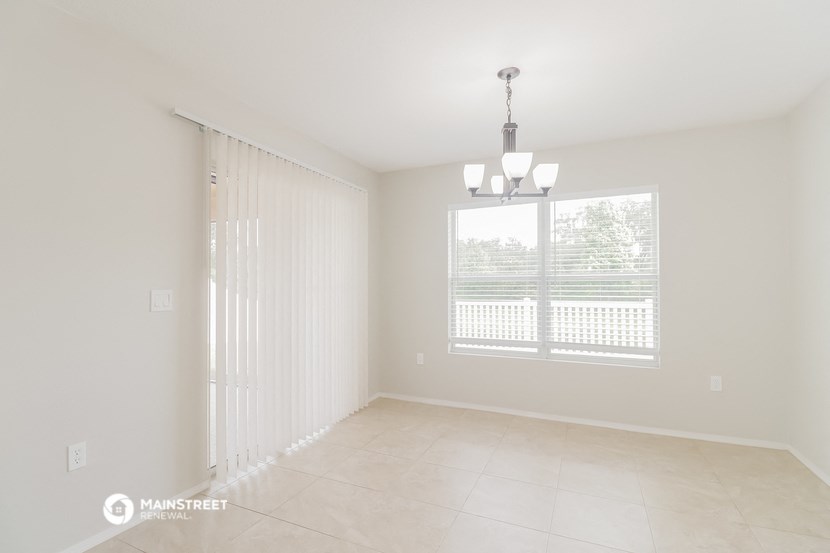 the living room and dining room of a house with a large window