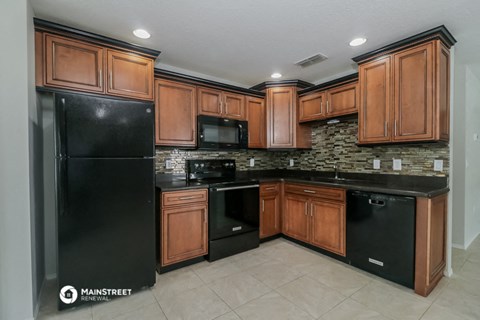 a kitchen with black appliances and wooden cabinets
