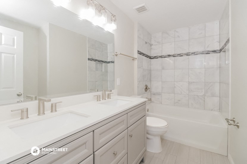 a white bathroom with a toilet and a sink