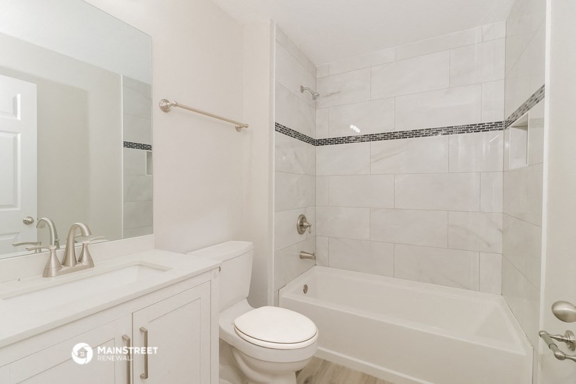 a white bathroom with a tub and a toilet and a sink