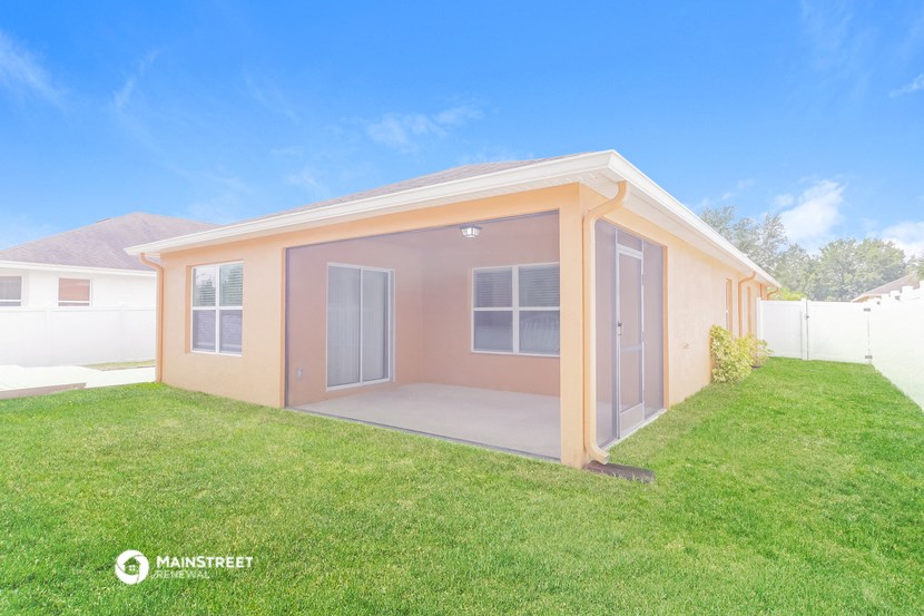 a small pink house with a grass yard and a lawn