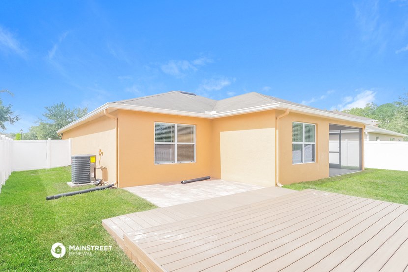 a house with a wooden deck and grass