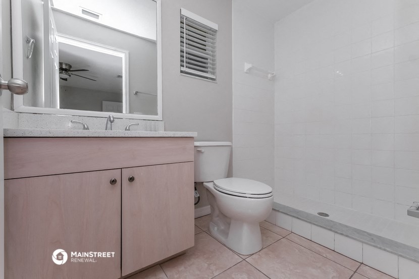 a bathroom with a toilet and a sink and a mirror