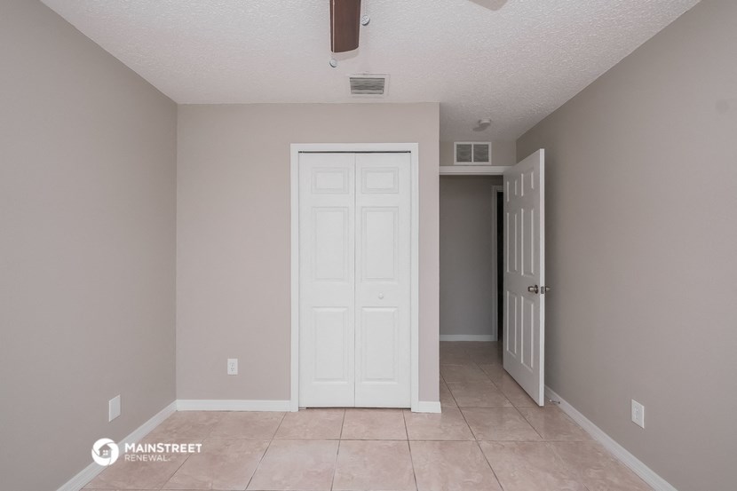 a room with a white door and a hallway with a door to a closet