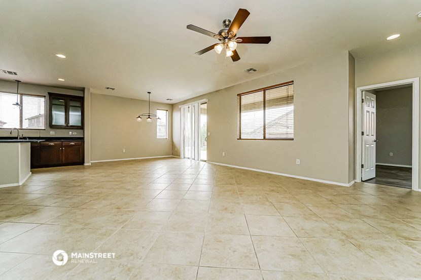 an empty kitchen and living room with a ceiling fan