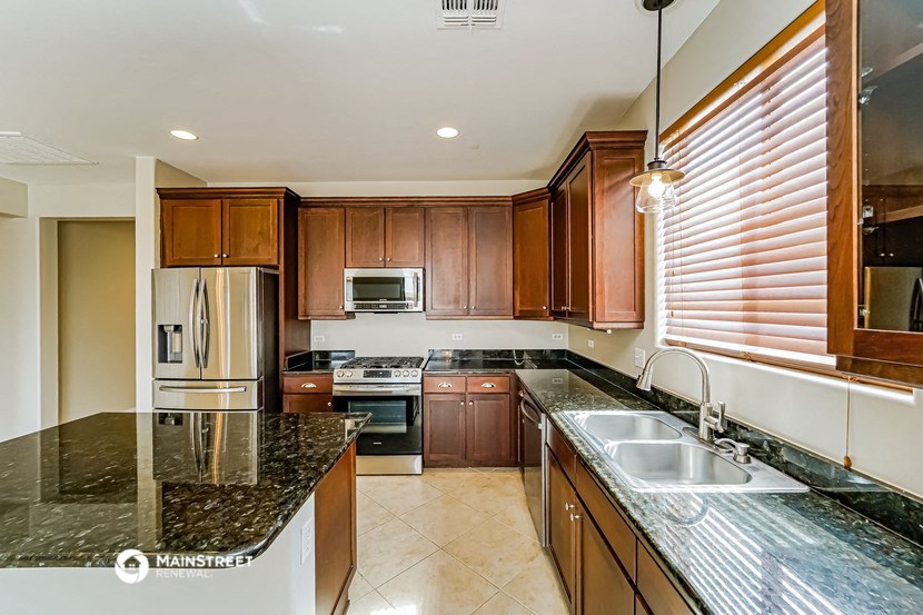 a kitchen with granite counter tops and wooden cabinets