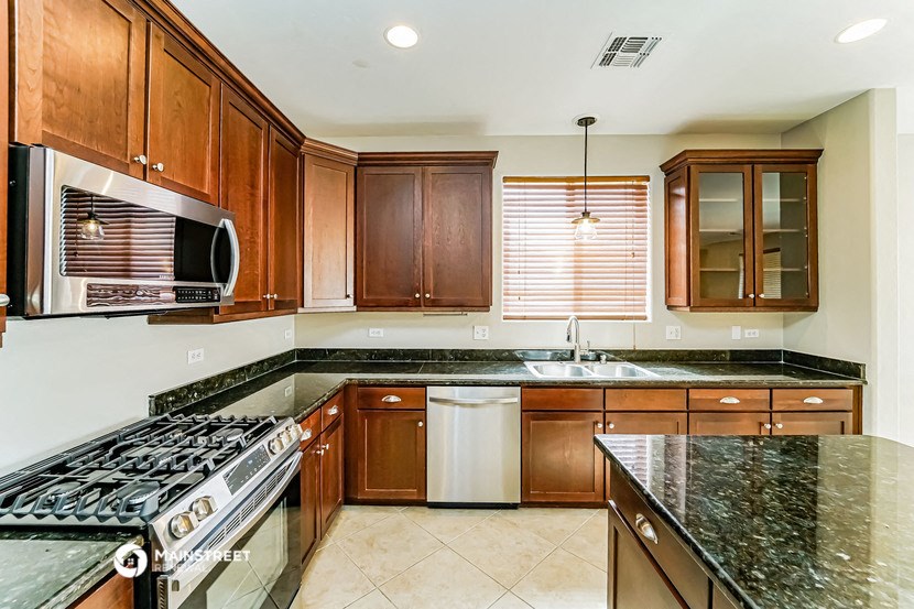 a kitchen with granite counter tops and wooden cabinets
