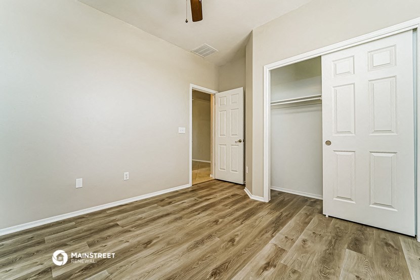 a bedroom with a closet and a door to a hallway