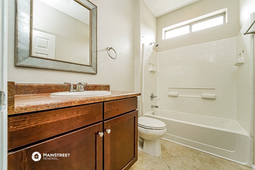 a bathroom with a toilet sink and shower and a mirror