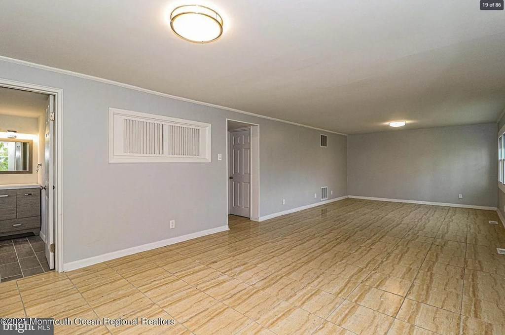 A spacious room with wooden flooring and a ceiling light.