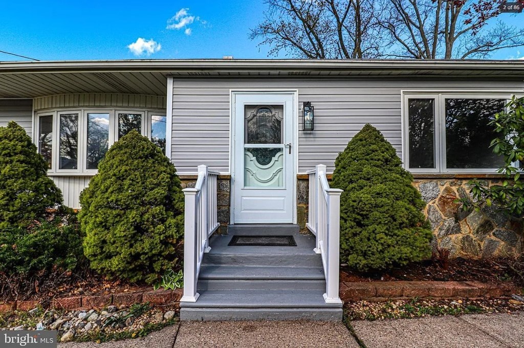 A house with a grey front and a white door.