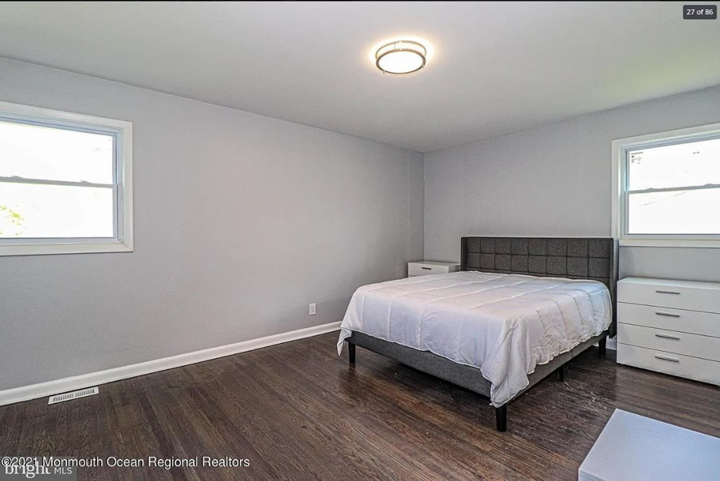 A bedroom with a bed, dresser, and window.