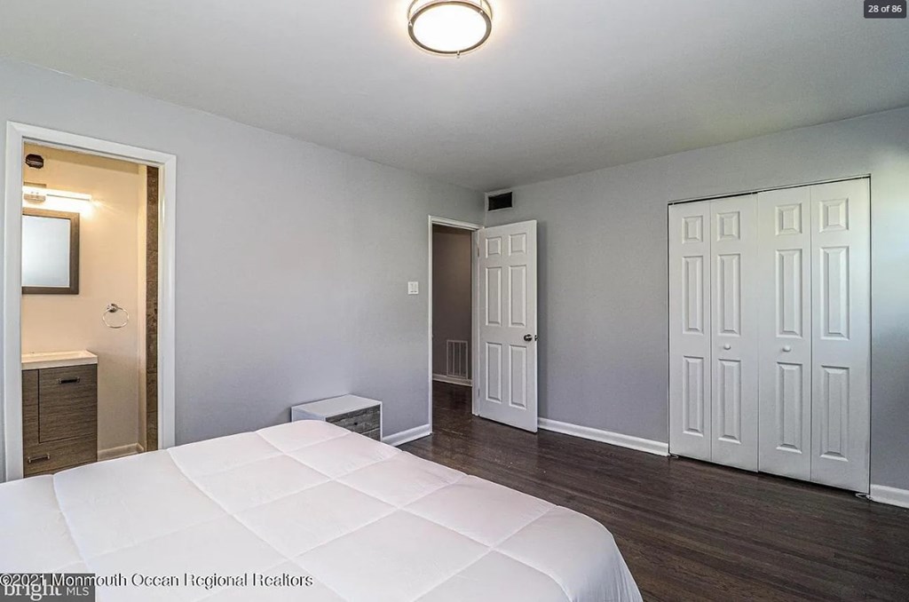 A bedroom with a large bed and a white door.