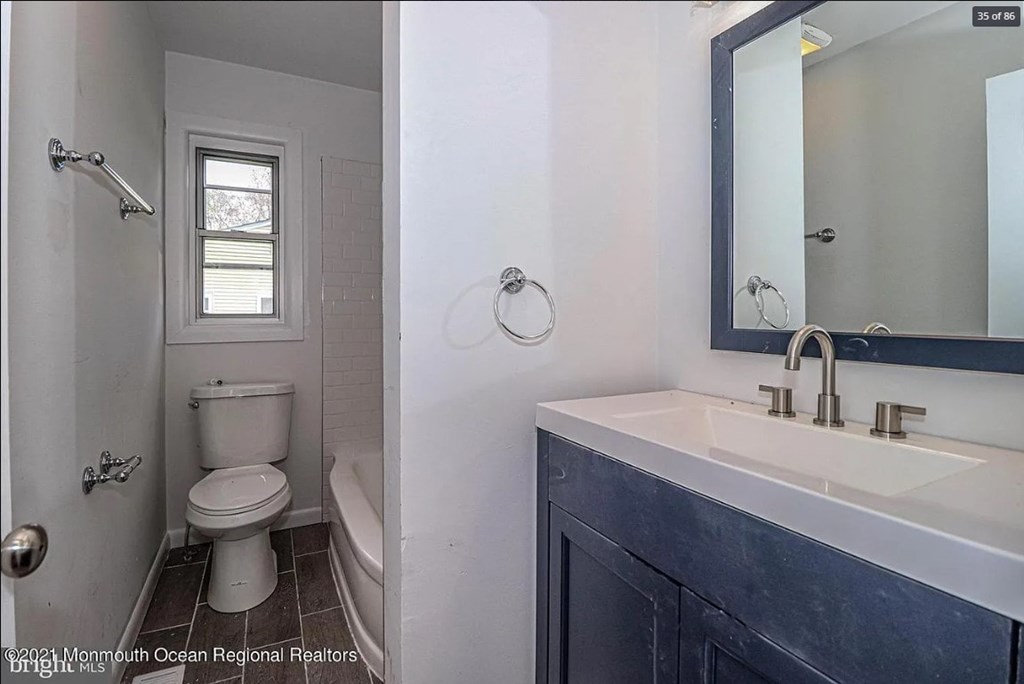 A small bathroom with a toilet, sink and shower.