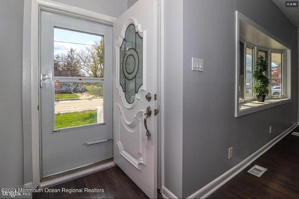 A white door with a glass window and a mirror on the wall.