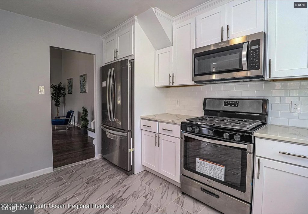 A kitchen with a stove, refrigerator, and microwave.