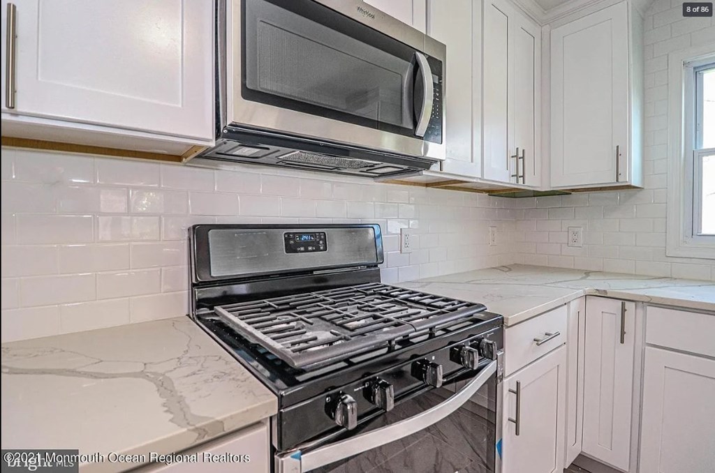 A kitchen with a stove top oven and microwave above it.