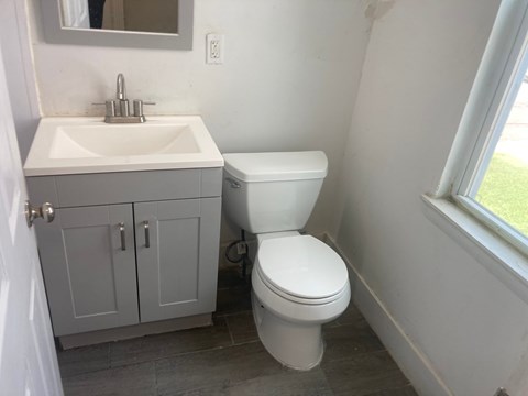 A white toilet sits next to a sink in a bathroom.