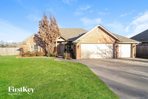 a brick house with a garage and a lawn